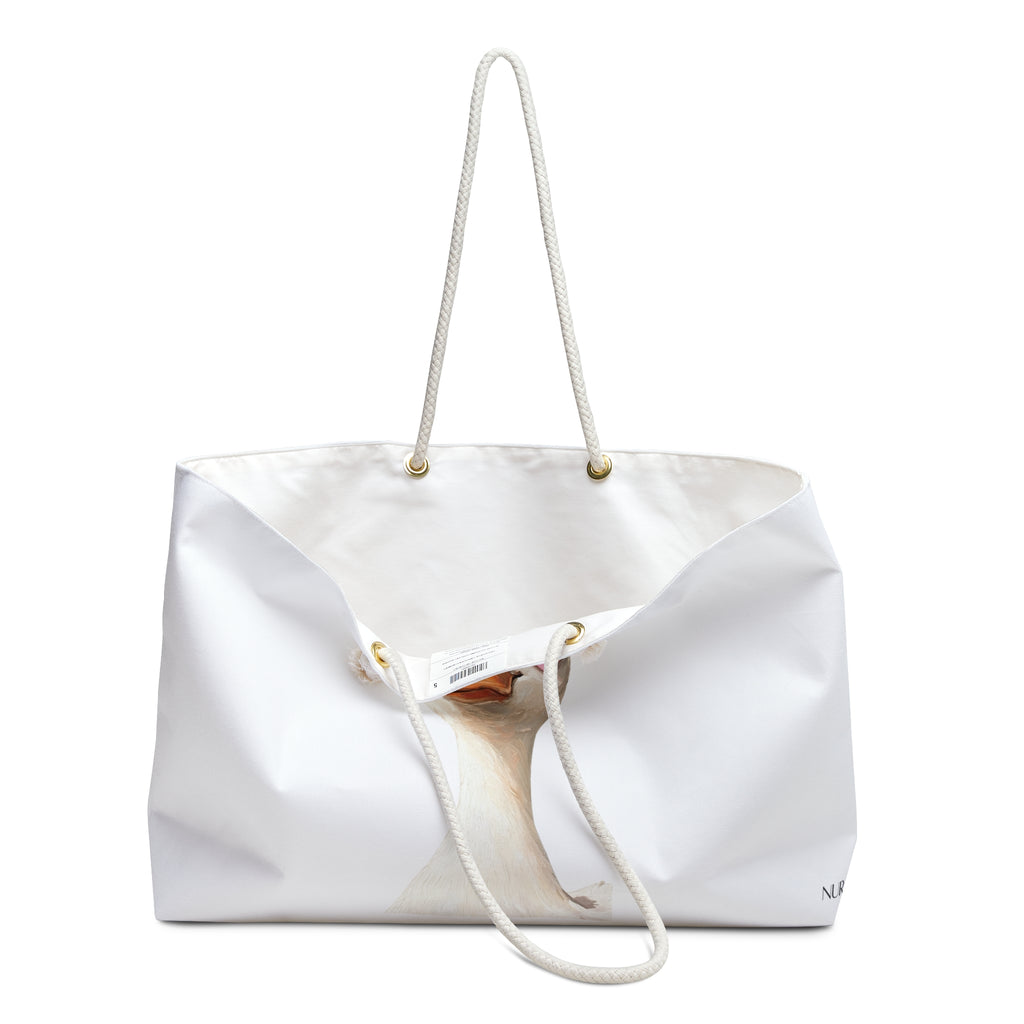 A white canvas tote bag with thick white rope handles and small gold-tone metal grommets, shown on a plain white background.