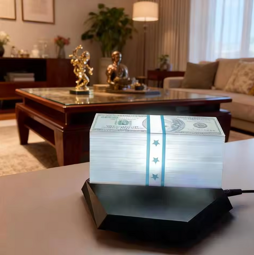 A black LED money box light on a table in a living room, illuminating a stack of US dollar bills bound with a blue band.