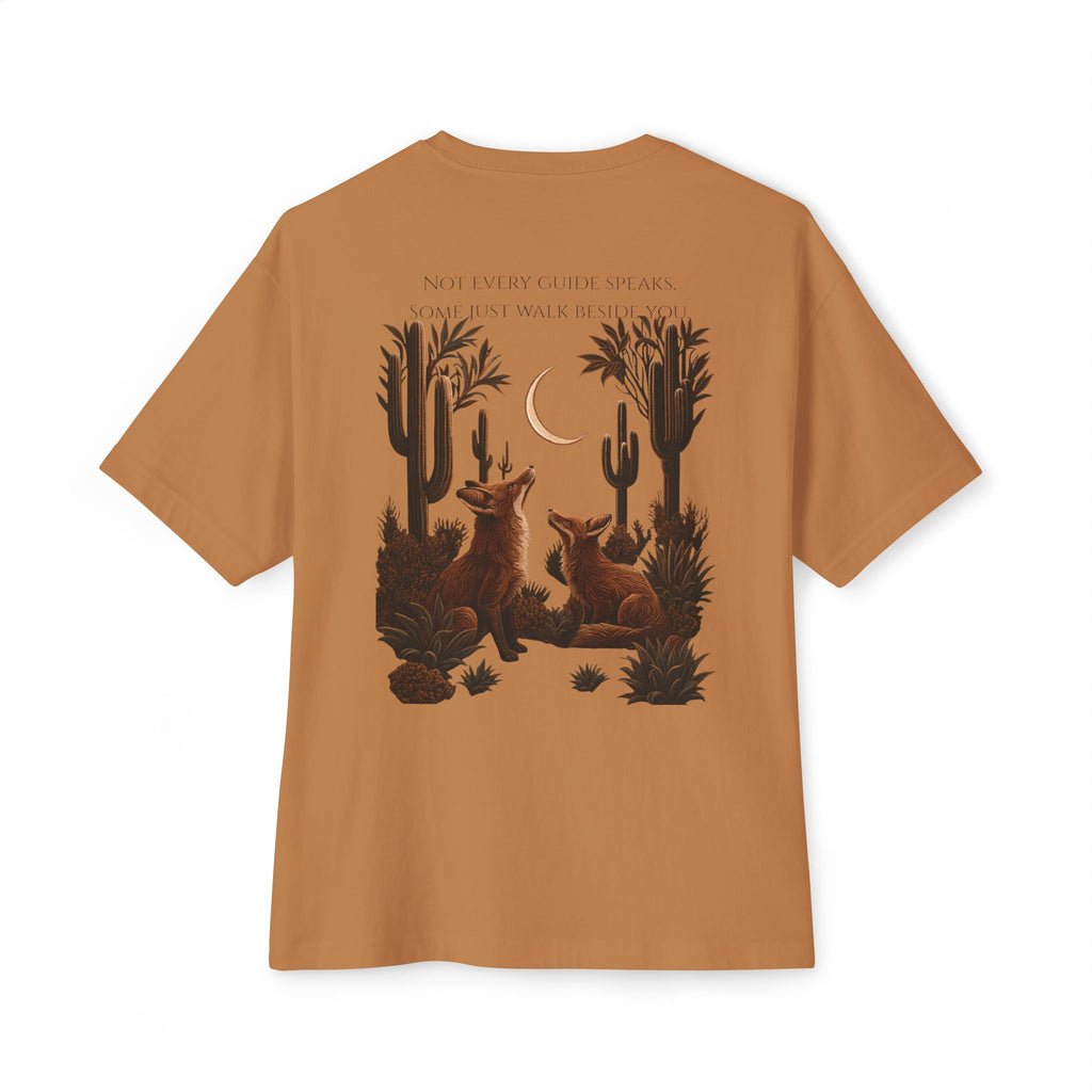 A tan short-sleeve t-shirt shown from the back, featuring a detailed desert graphic of two foxes under a crescent moon with cacti and the text 'NOT EVERY GUIDE SPEAKS. SOME JUST WALK IN SHADOW.