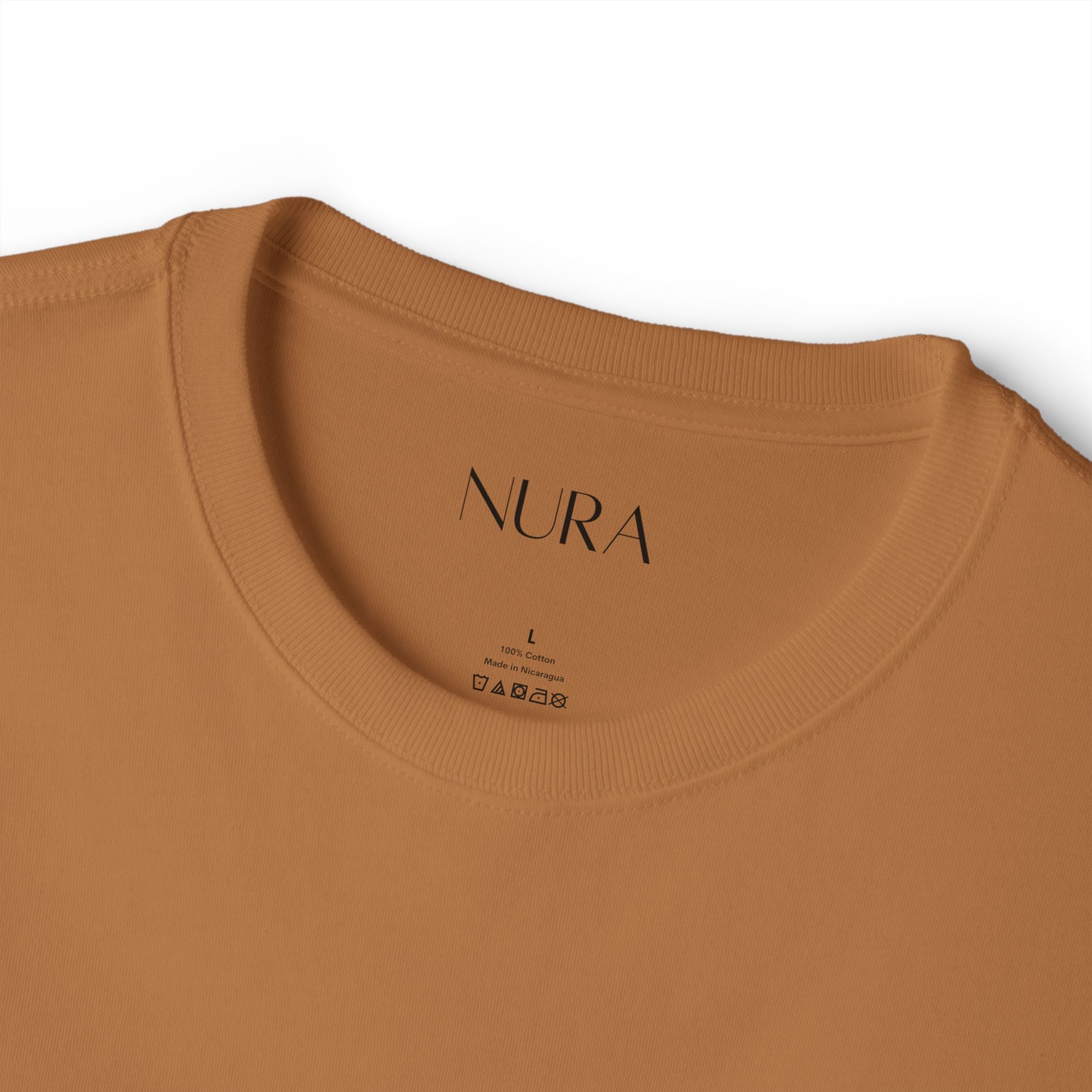 Close-up of a crewneck t-shirt in a warm camel brown color, showing the inner neck label with the brand 'FINE PRINT STUDIOS'.