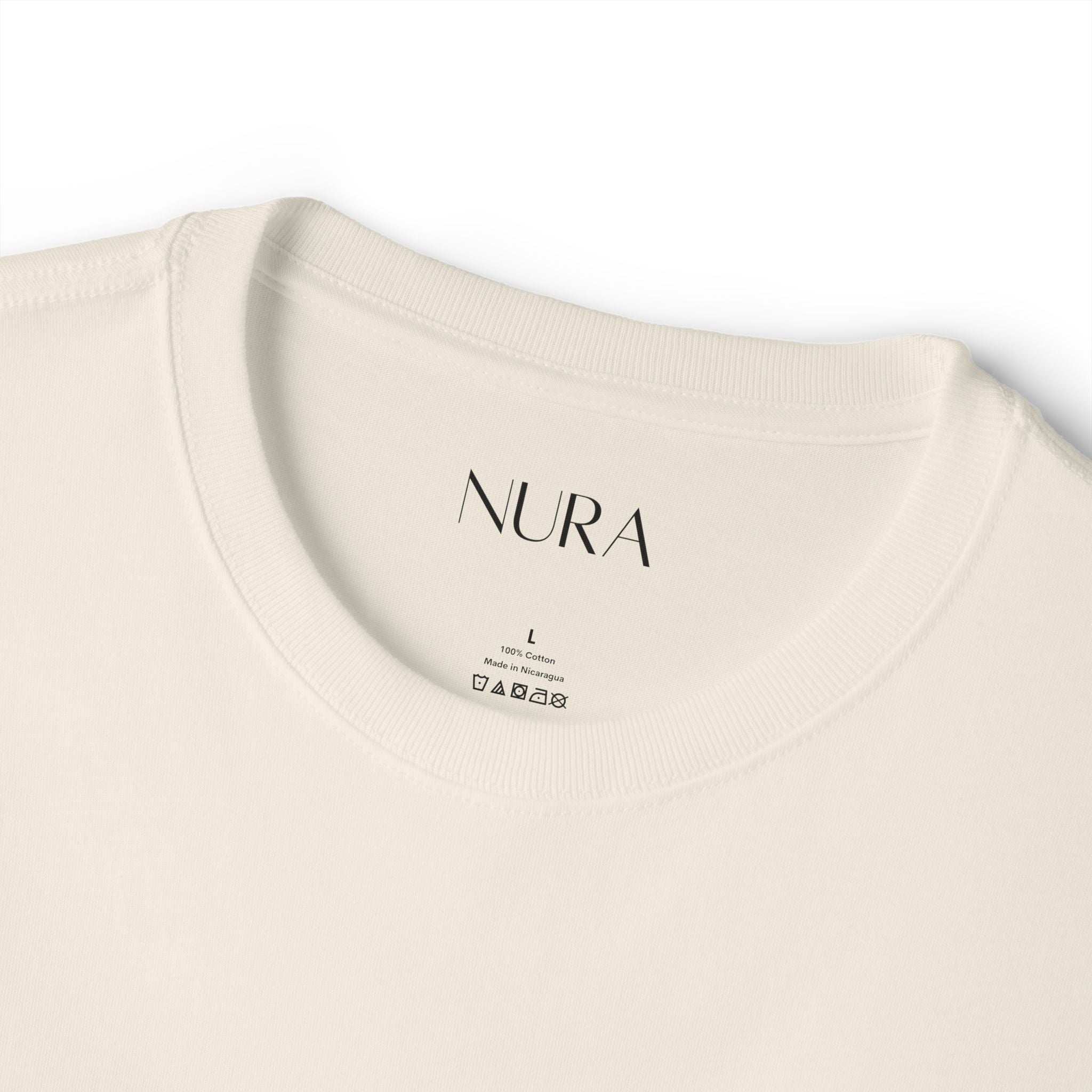 Close-up of a cream-colored crewneck t-shirt showing the inside collar with the brand name 'NURA' printed in black.